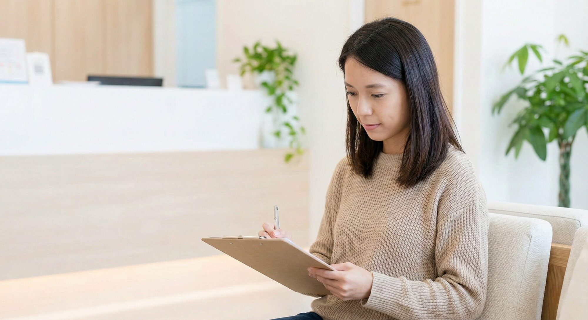 クリニックで問診票を記入する女性
